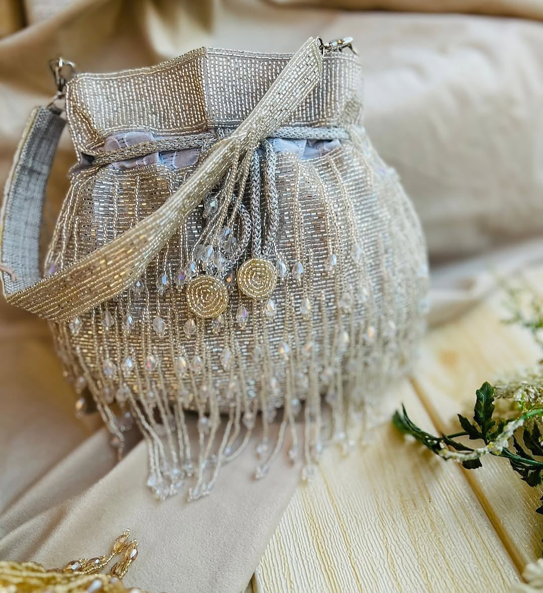 Meher hand-beaded potli in champagne with crystal drop fringe and detachable beaded strap