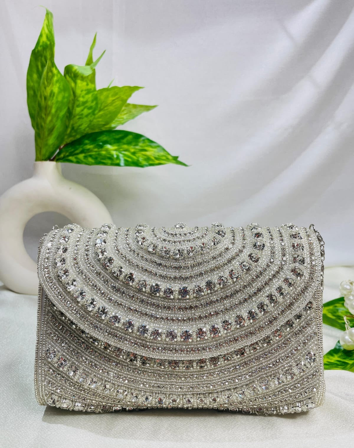 Roshni crystal flap clutch in silver with scalloped rows of hand-set stones